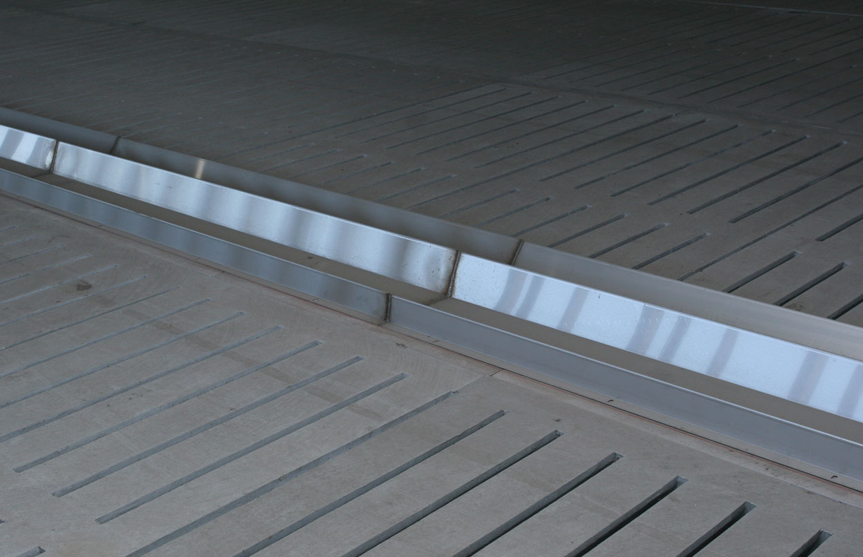 Stainless steel sow feeding trough can be installed with stanchion layouts to create feeding space on total slat barns and/or protect concrete surfaces from the damaging effects of feed and water over time. (Shown: Double-sided stainless steel sow feeding trough in a total slat floor barn.